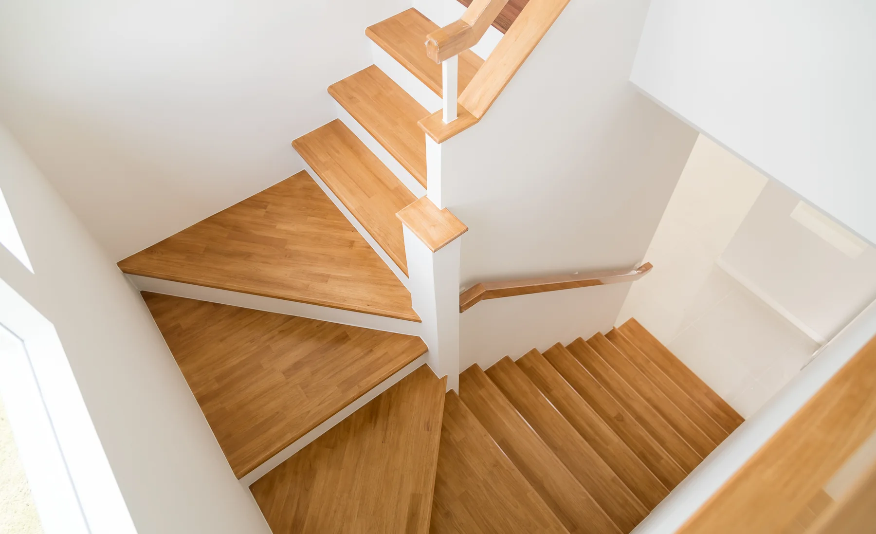 Helle gewendelte Holztreppe mit offenem Treppenauge