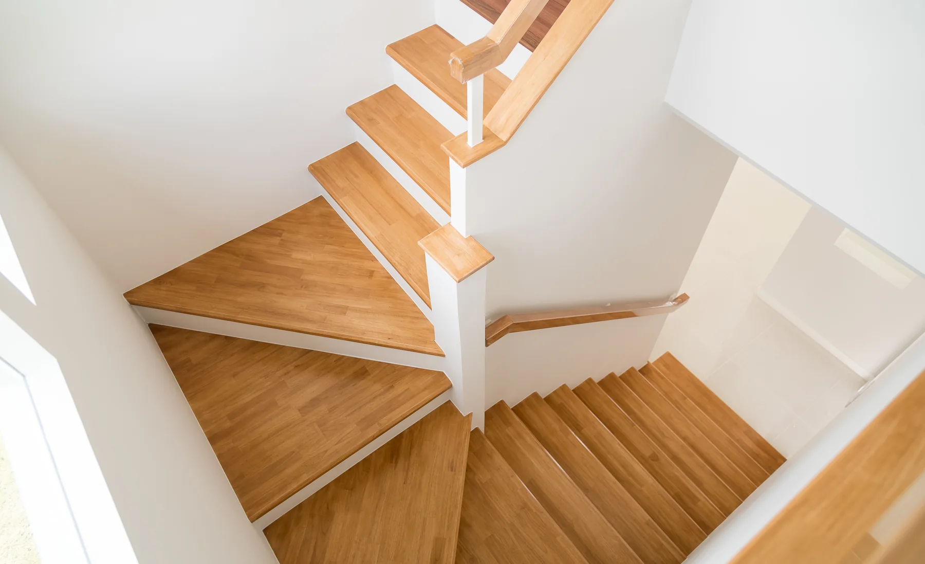 Helle gewendelte Holztreppe mit offenem Treppenauge