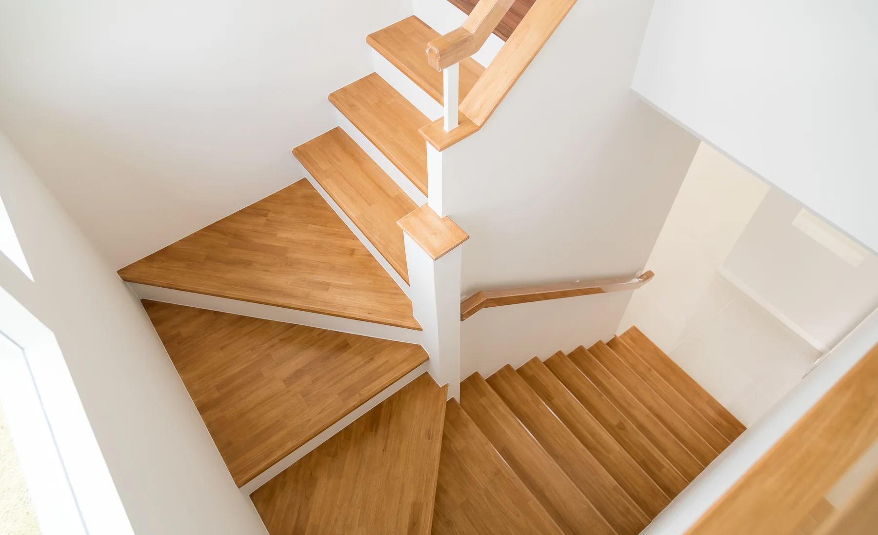 Helle gewendelte Holztreppe mit offenem Treppenauge
